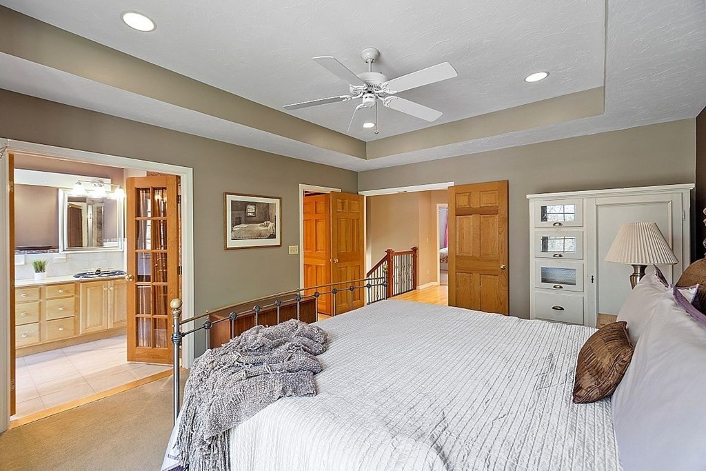 793 Reservoir Road Lunenburg, MA 01462 - Photo 19 of 39 a bedroom with a large bed and a chandelier