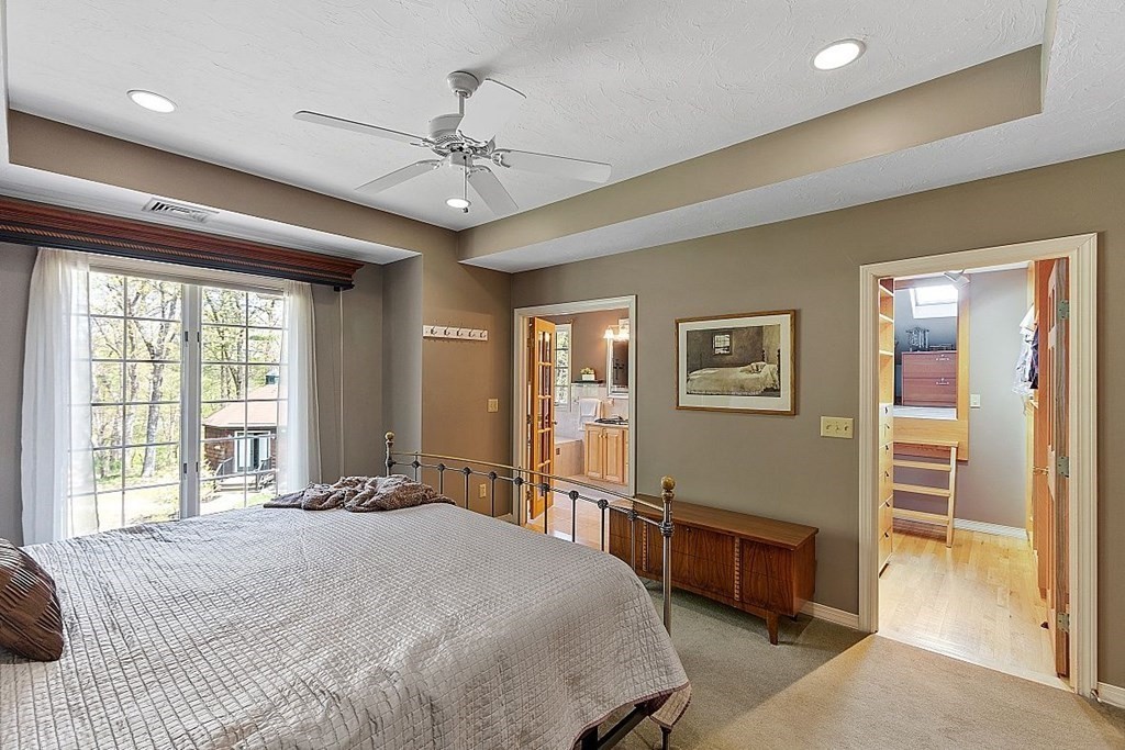 793 Reservoir Road Lunenburg, MA 01462 - Photo 20 of 39 a spacious bedroom with a bed and a chandelier