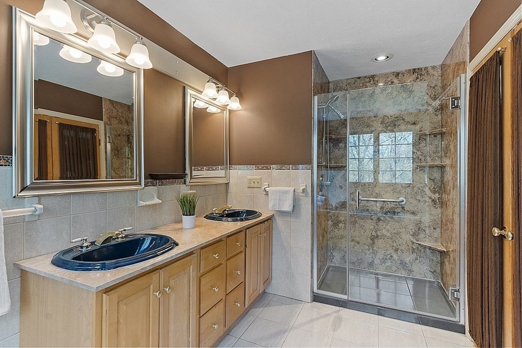 793 Reservoir Road Lunenburg, MA 01462 - Photo 22 of 39 a bathroom with a sink a mirror and a shower