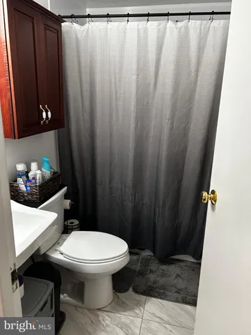 a bathroom with a toilet and a shower curtain