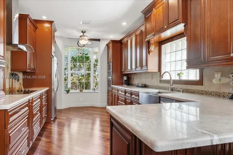 a kitchen with stainless steel appliances granite countertop a sink stove and refrigerator
