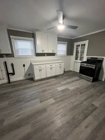 a view of a kitchen with wooden floor and electronic appliances