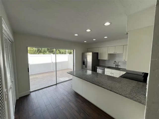 a large kitchen with a large window and stainless steel appliances