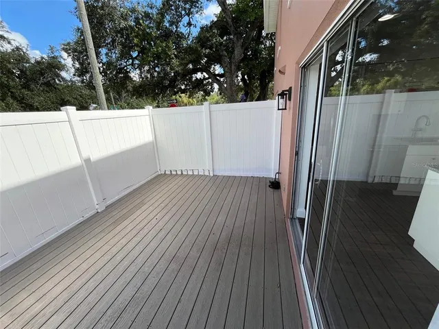 a view of a balcony with wooden floor and fence