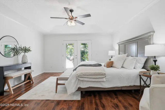 a bedroom with a bed a chandelier and a mirror