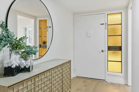 an entryway with wooden floor and a window