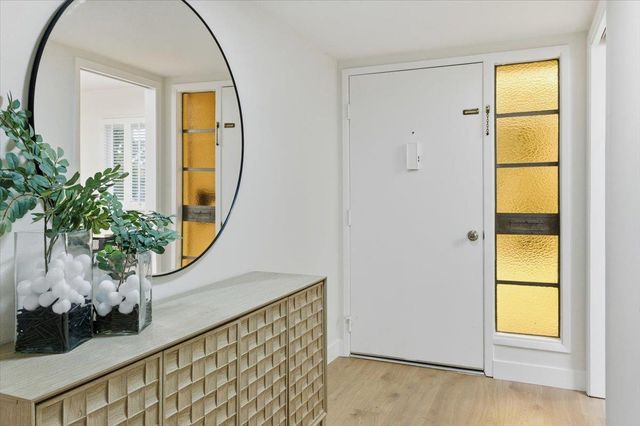 an entryway with wooden floor and a window