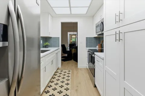 a kitchen with granite countertop a refrigerator and a sink