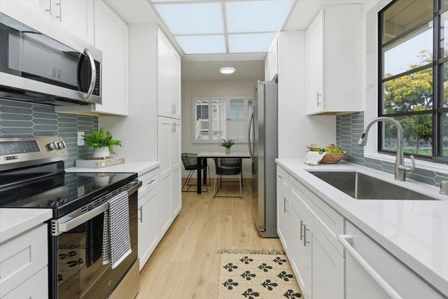 a kitchen with stainless steel appliances a stove sink microwave and cabinets