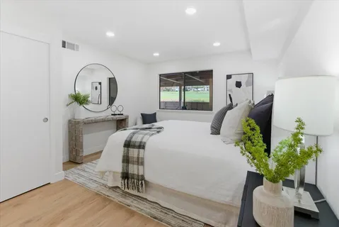 a bedroom with a bed and a potted plant