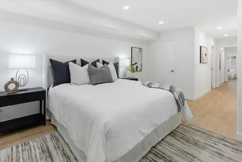 a large bed sitting in a bedroom next to a lamp