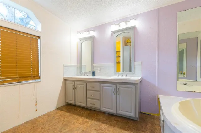 a spacious bathroom with a granite countertop tub sink and mirror