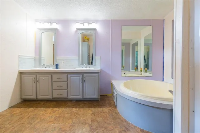 a bathroom with a tub a sink and a window