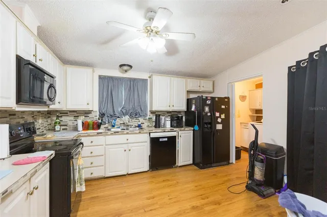 a kitchen with a refrigerator sink and cabinets