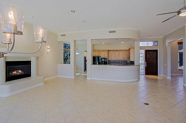 a view of an empty room and a kitchen