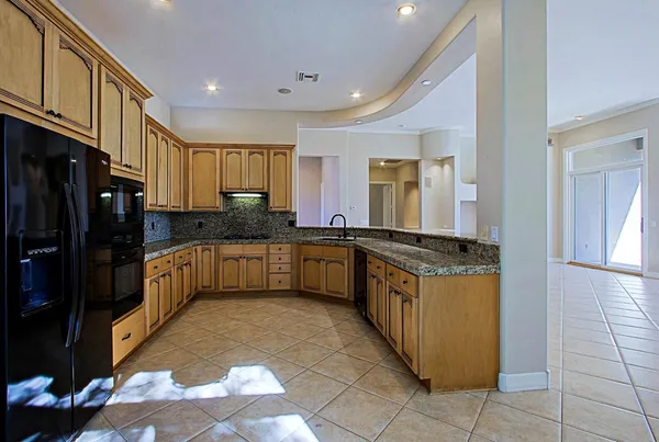 a kitchen with stainless steel appliances granite countertop a stove a sink and a refrigerator
