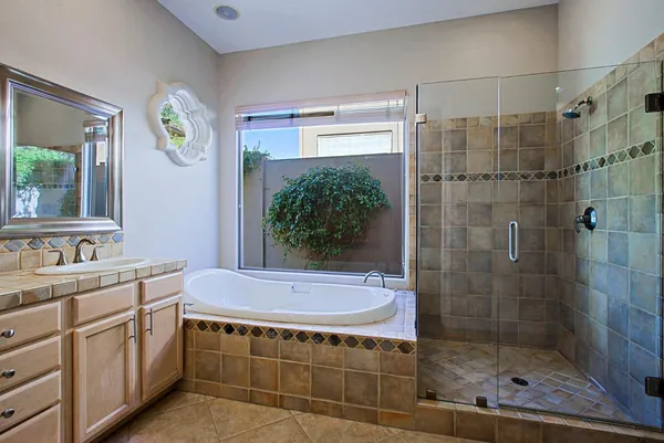 a bathroom with a bathtub shower sink mirror and toilet