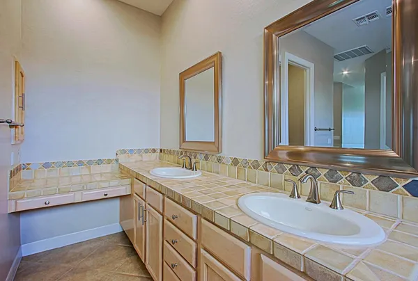 a bathroom with a granite countertop sink and a mirror