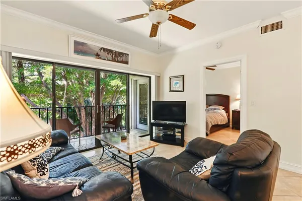 a living room with furniture a flat screen tv and a large window