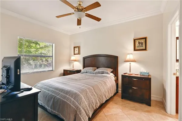 a bedroom with a bed and a flat tv screen on the dresser