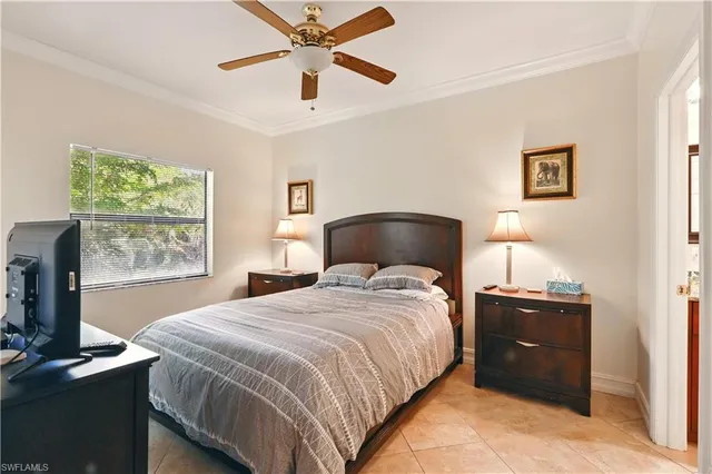 a bedroom with a bed and a flat tv screen on the dresser