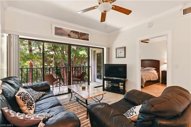 a living room with furniture a flat screen tv and a large window