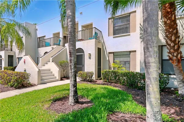 a front view of a house with a yard and plants