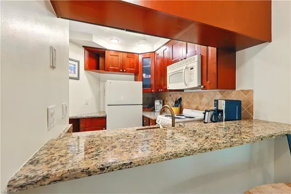 a kitchen with stainless steel appliances granite countertop a sink refrigerator and cabinets