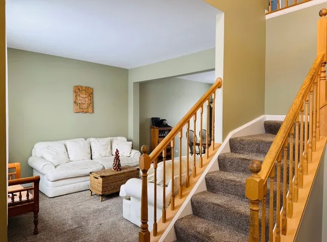 a living room with furniture and stairs