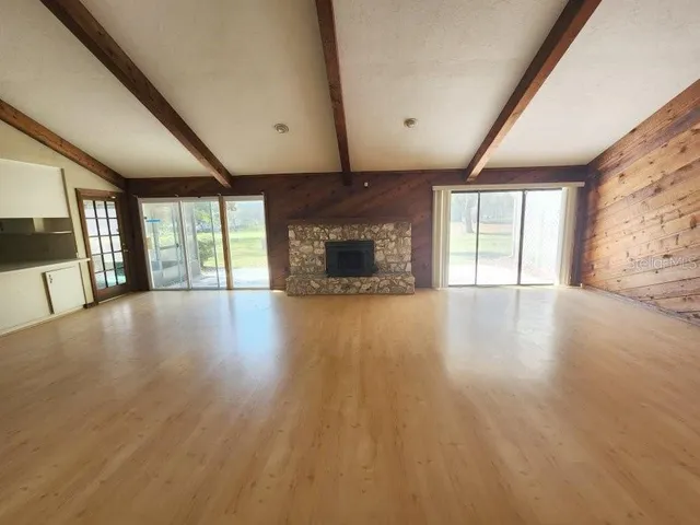 an empty room with wooden floor and fireplace