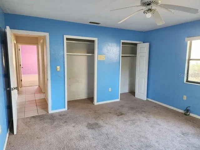 an empty room with closet and windows