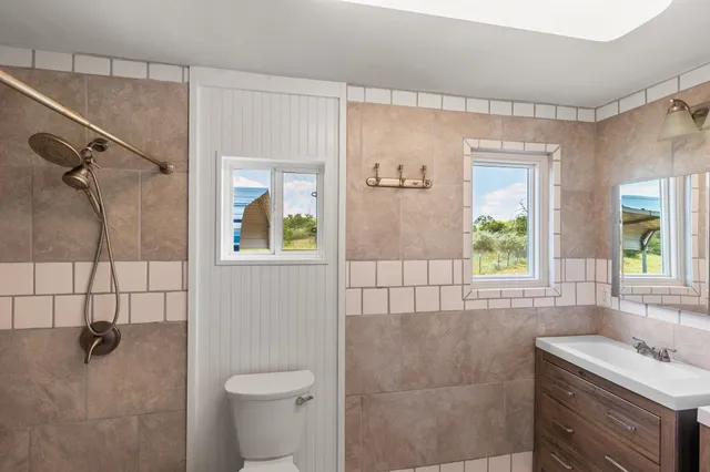 a bathroom with a granite countertop sink a toilet and shower