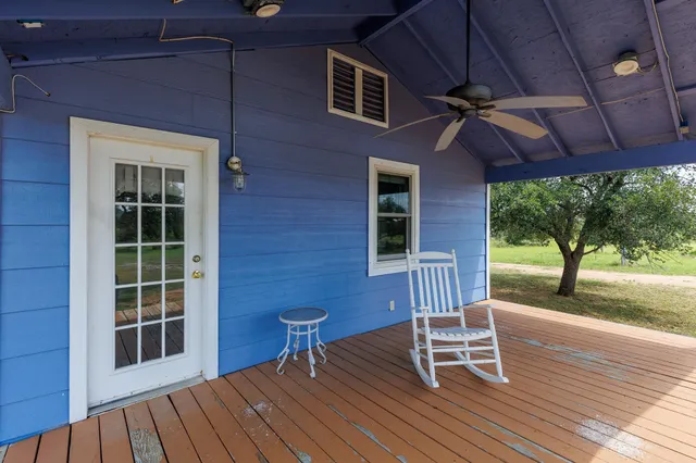 a view of a patio with a table chairs and wooden floor