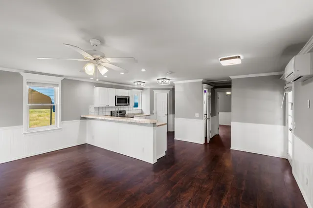 a view of a kitchen with a sink a refrigerator and wooden floor
