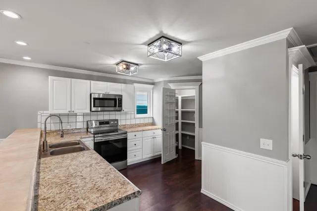 a kitchen with stainless steel appliances granite countertop a sink dishwasher stove and refrigerator