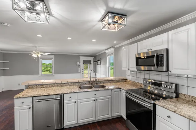 a kitchen with stainless steel appliances granite countertop a sink and stove top oven