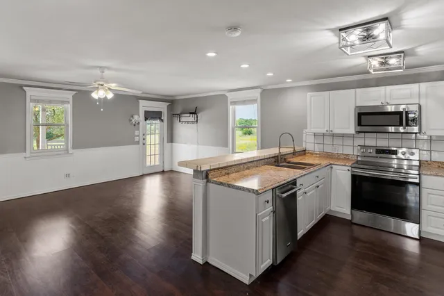 a kitchen with a stove and a microwave oven on the wooden floor