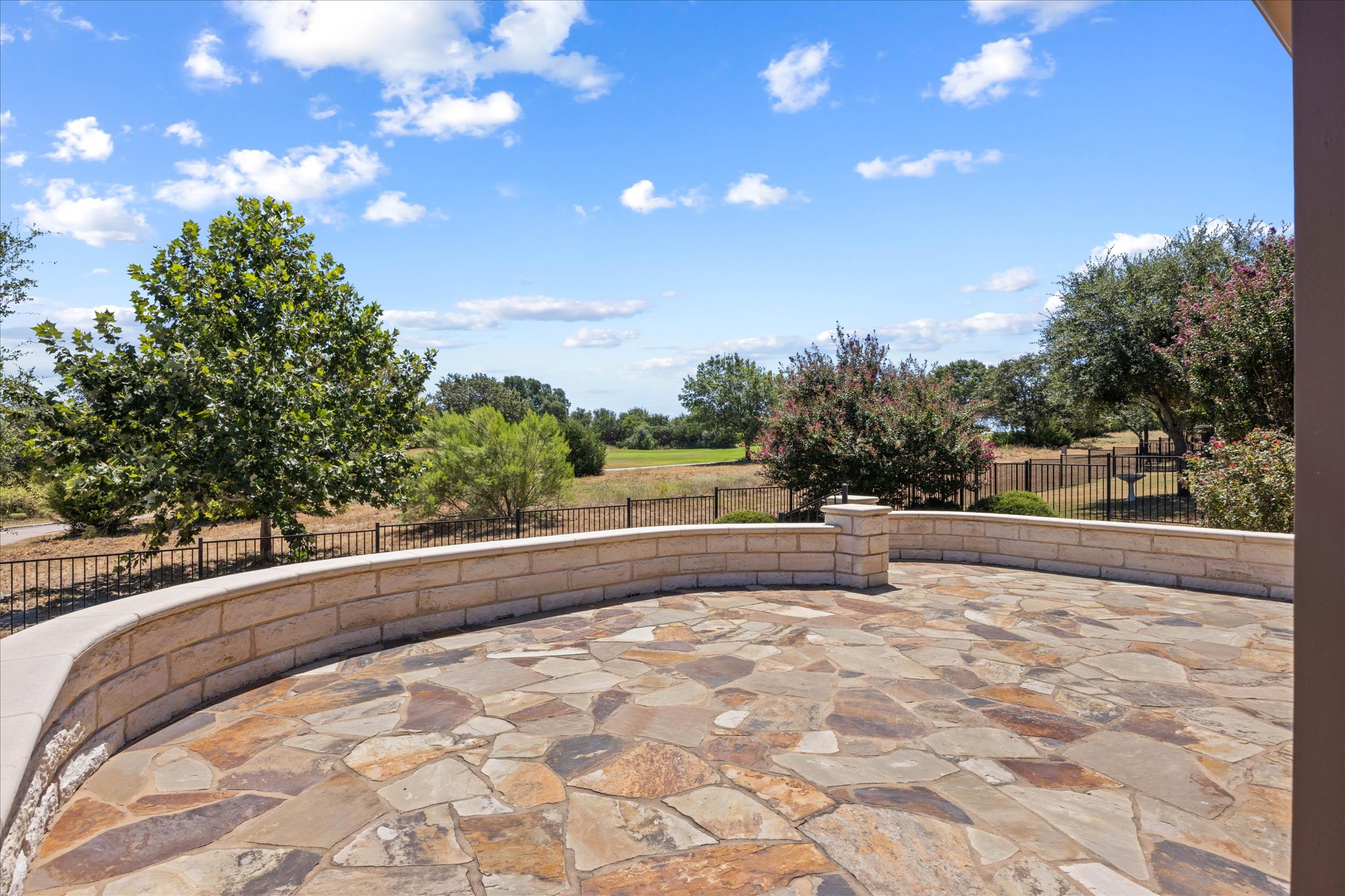 103 McKittrick Ridge Road Georgetown, TX 78633 - Photo 17 of 23 A spacious flagstone patio offers open views of the surrounding green landscape and distant trees.