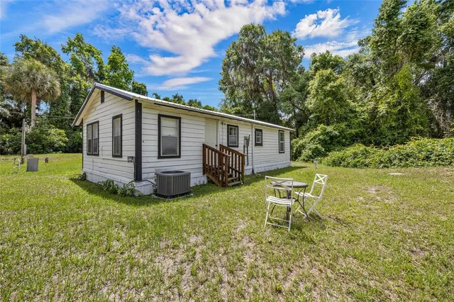 a view of a house with backyard sitting area and garden