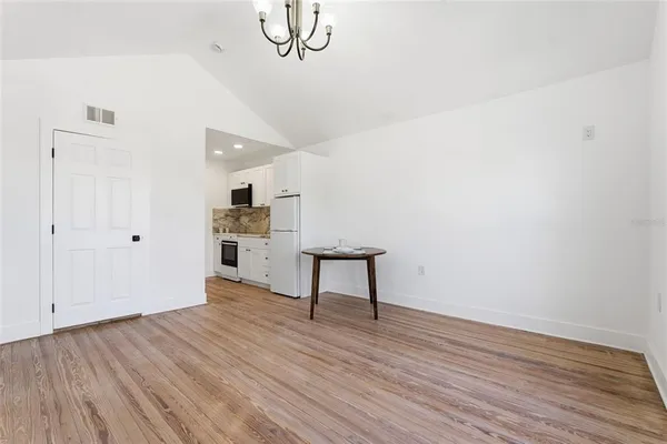 a view of a room with wooden floor and white walls