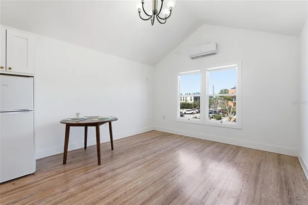 a view of an empty room with window and wooden floor