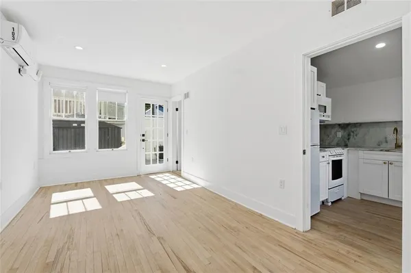 a view of kitchen with white cabinets and wooden floor