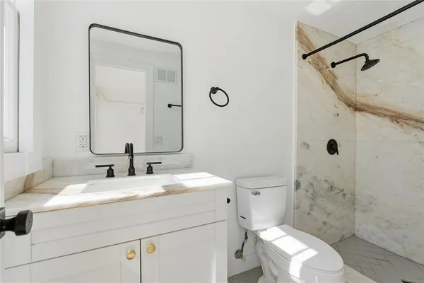 a bathroom with a sink a toilet and shower