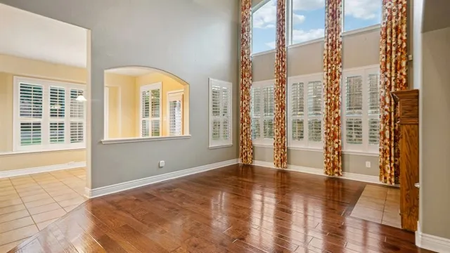 a view of empty room with floor to ceiling window and wooden floor