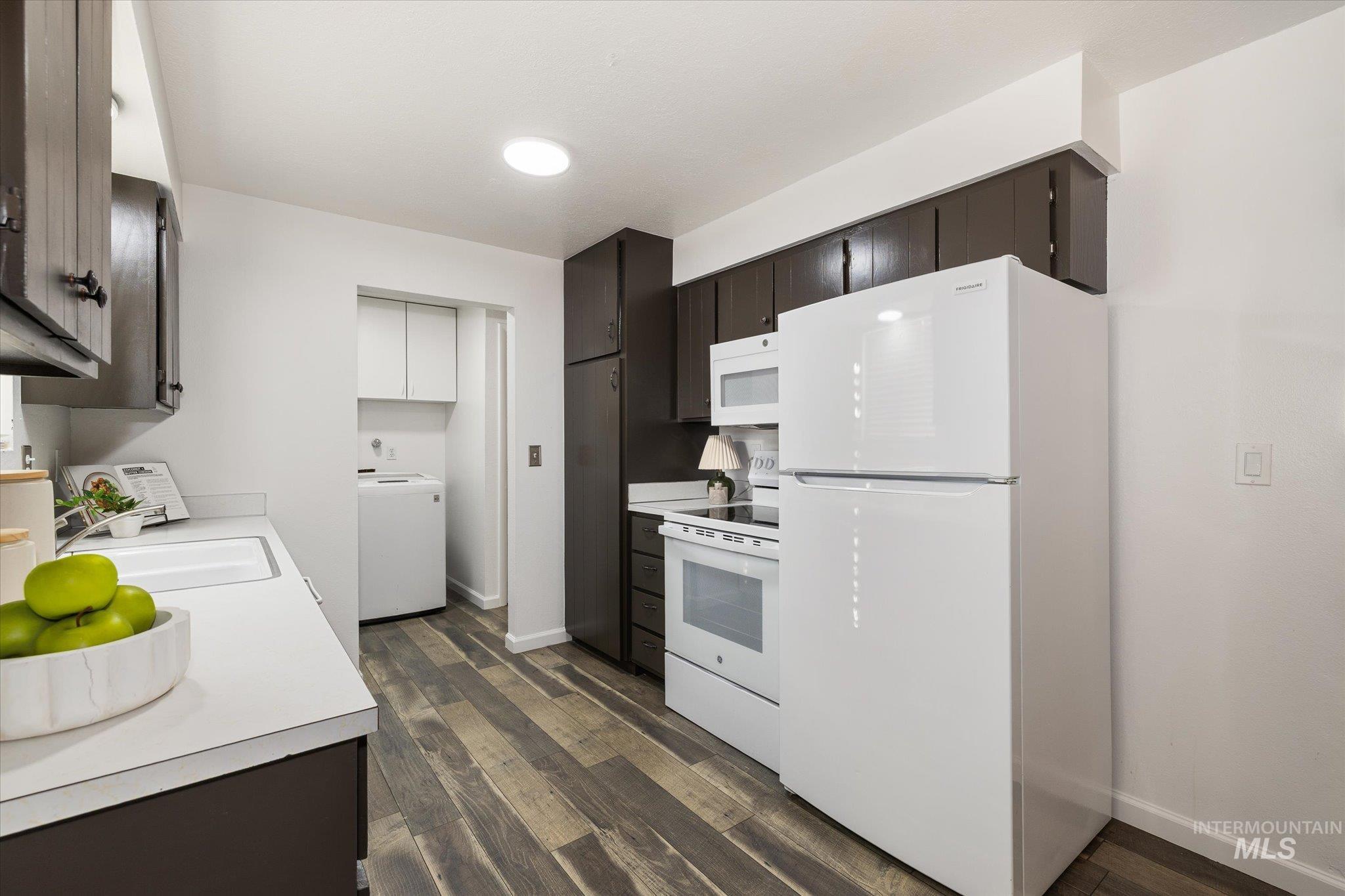 2302 Pendleton Street Boise, ID 83705 - Photo 14 of 35 Kitchen featuring wood-finish flooring, white appliances, dark cabinetry, and white countertops