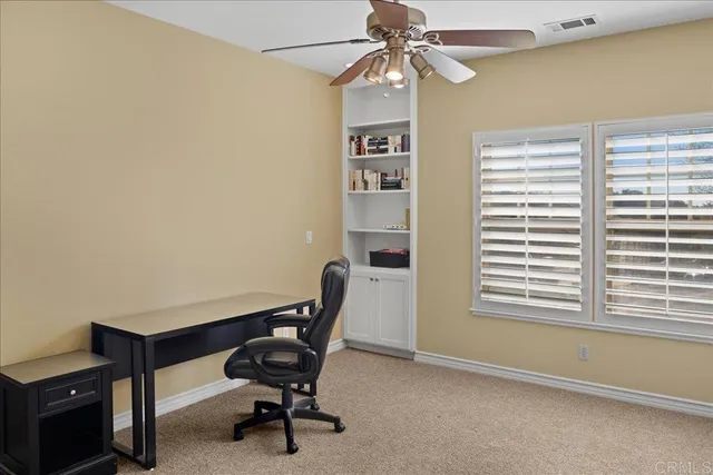 a view of a workspace with furniture and a window