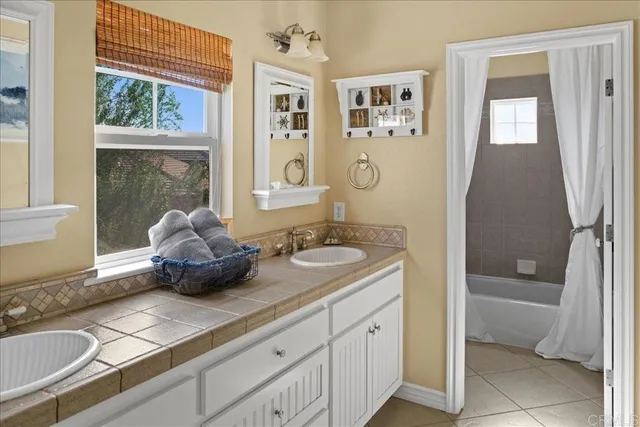 a bathroom with a granite countertop sink a mirror and a bathtub