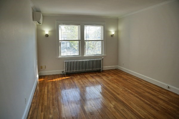 95 Adams Street, Unit 9 Waltham, MA 02453 - Photo 7 of 8 an empty room with wooden floor and windows