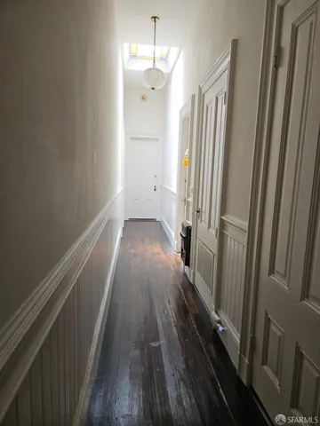 a view of a hallway with wooden floor and staircase