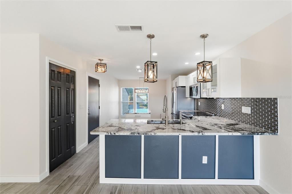 3405 Clark Road, Unit 205 Sarasota, FL 34231 - Photo 12 of 38 a kitchen with kitchen island granite countertop a sink a counter top space and cabinets